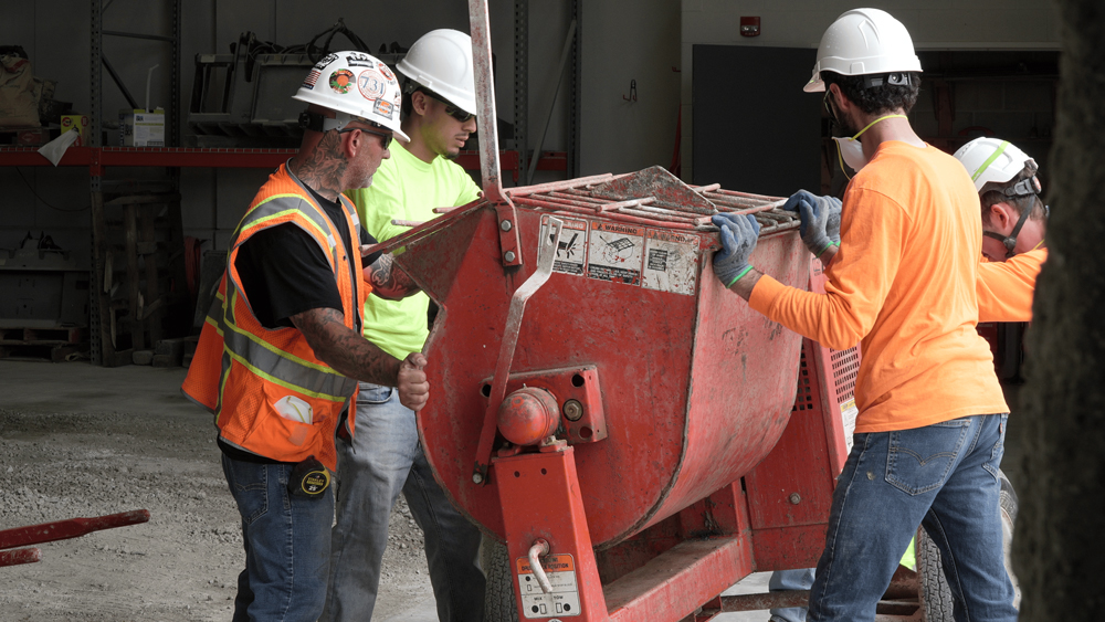 construction workers monitoring a cement mixer